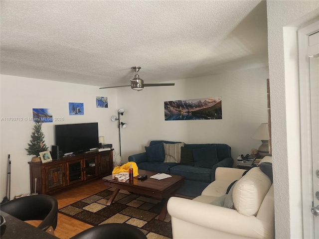 living room featuring a ceiling fan, a textured ceiling, and wood finished floors
