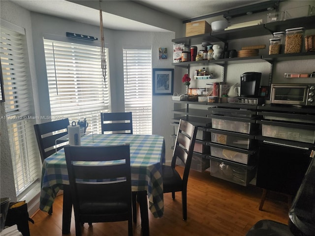 dining space featuring wood finished floors and a toaster