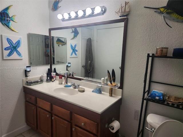 bathroom featuring vanity, tile patterned floors, and toilet