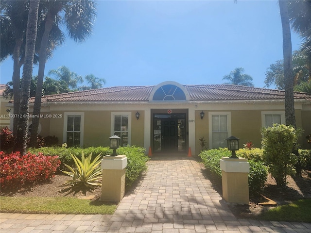 exterior space with stucco siding and a tile roof