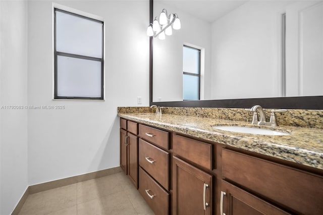 bathroom with a sink, baseboards, tile patterned flooring, and double vanity