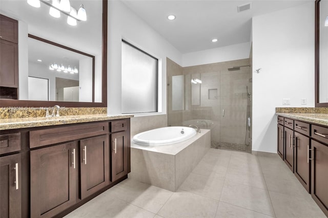 bathroom with a sink, tile patterned flooring, visible vents, a garden tub, and a stall shower