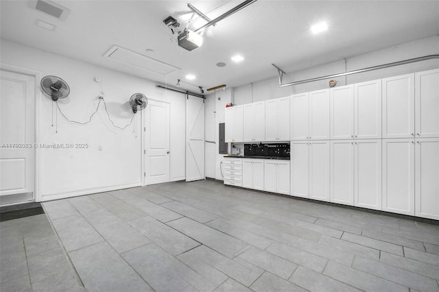 garage with a garage door opener and electric panel