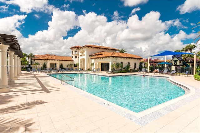community pool featuring fence and a patio area