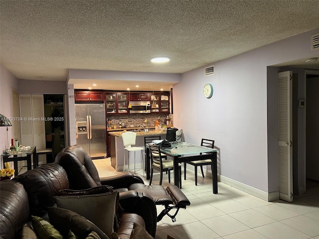 460 W Park Dr Unit 103, Miami, FL 33172 - living room featuring a textured ceiling, wet bar, visible vents, light tile patterned floors, and baseboards
