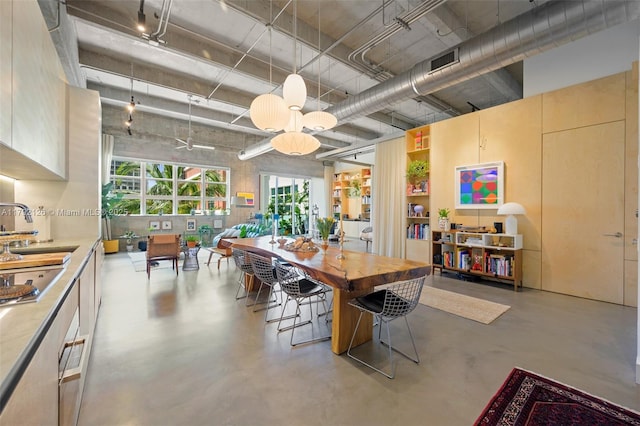 dining area featuring visible vents, concrete flooring, and a high ceiling