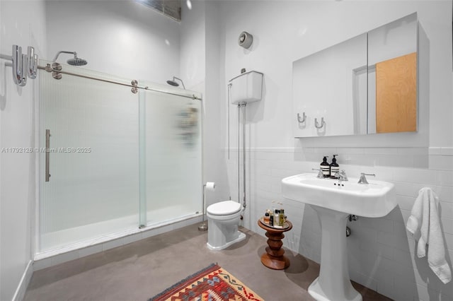 full bathroom with concrete floors, a wainscoted wall, toilet, and a shower stall