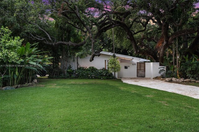 1075 NE 99th St, Miami Shores, FL 33138 - view of grassy yard featuring concrete driveway