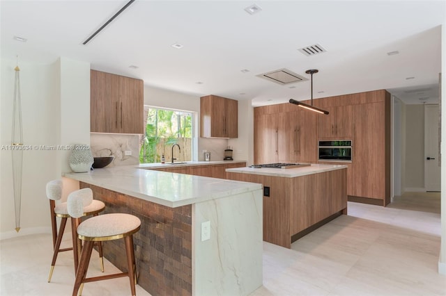kitchen featuring visible vents, brown cabinetry, and modern cabinets