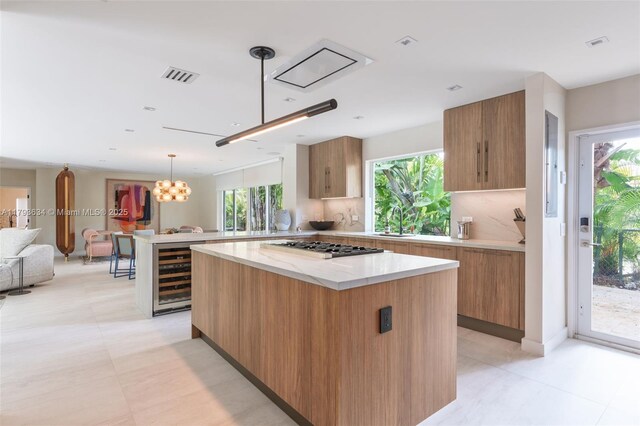 1075 NE 99th St, Miami Shores, FL 33138 - kitchen with beverage cooler, modern cabinets, stainless steel gas stovetop, brown cabinetry, and open floor plan