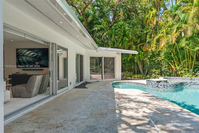 pool featuring a patio and an in ground hot tub