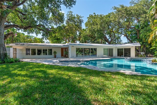 1075 NE 99th St, Miami Shores, FL 33138 - rear view of property featuring a patio, a yard, an outdoor pool, and stucco siding