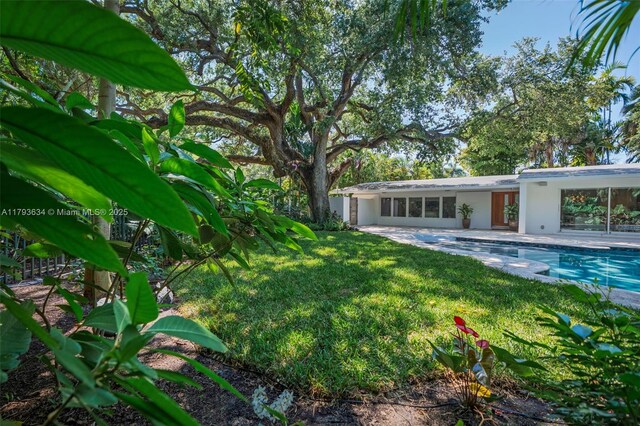 1075 NE 99th St, Miami Shores, FL 33138 - view of grassy yard featuring an outdoor pool and a patio area