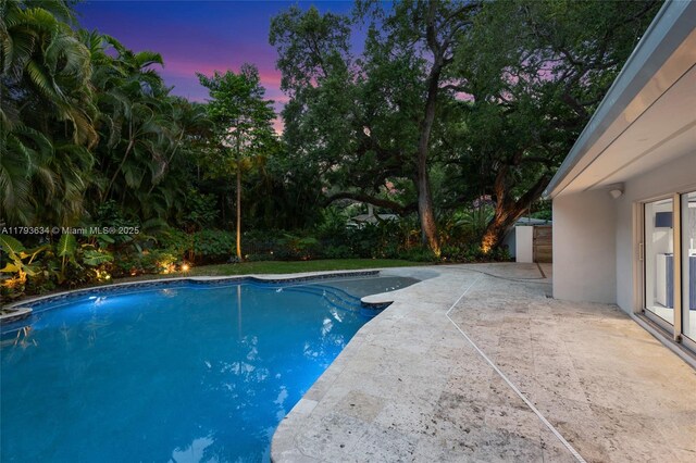 1075 NE 99th St, Miami Shores, FL 33138 - pool at dusk with a patio and an outdoor pool