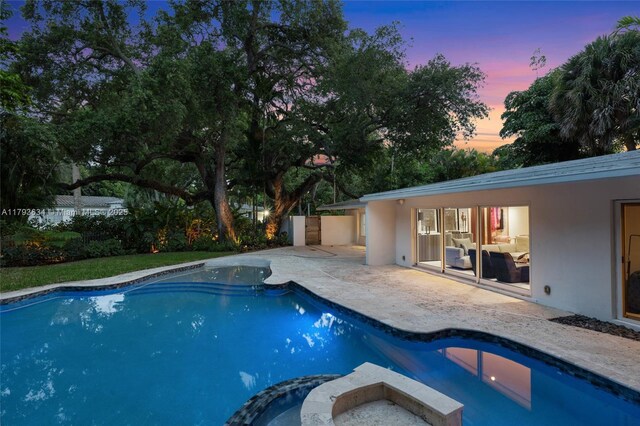 1075 NE 99th St, Miami Shores, FL 33138 - pool at dusk featuring a patio area