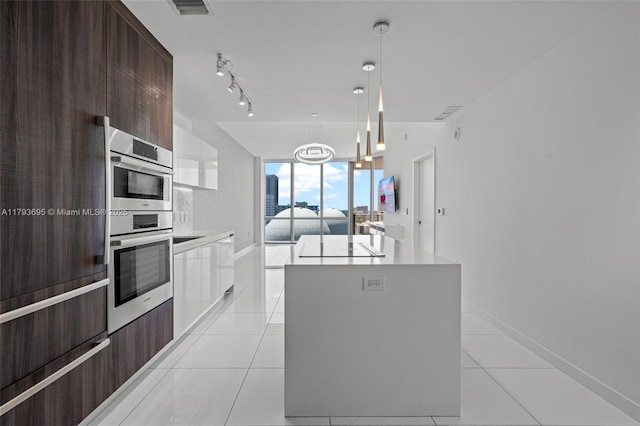 851 NE 1st Ave Unit 1506, Miami, FL 33132 - kitchen featuring floor to ceiling windows, modern cabinets, dark brown cabinets, light tile patterned floors, and light countertops