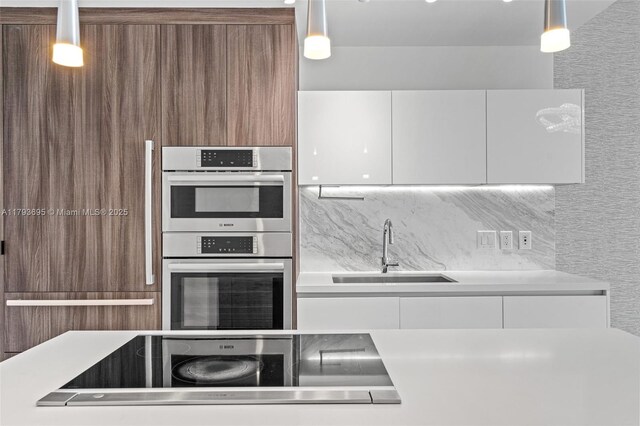 851 NE 1st Ave Unit 1506, Miami, FL 33132 - kitchen featuring stainless steel double oven, modern cabinets, a sink, light countertops, and white cabinetry