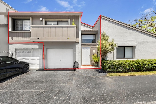 10761 SW 113th Pl Unit 102D, Miami, FL 33176 - view of front of property with an attached garage, driveway, a balcony, and stucco siding