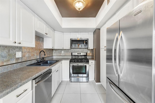 10761 SW 113th Pl Unit 102D, Miami, FL 33176 - kitchen featuring light tile patterned floors, white cabinets, a sink, backsplash, and stainless steel appliances