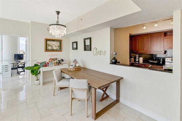 333 Las Olas Way Unit 2401, Fort Lauderdale, FL 33301 - dining space featuring rail lighting, a chandelier, and baseboards
