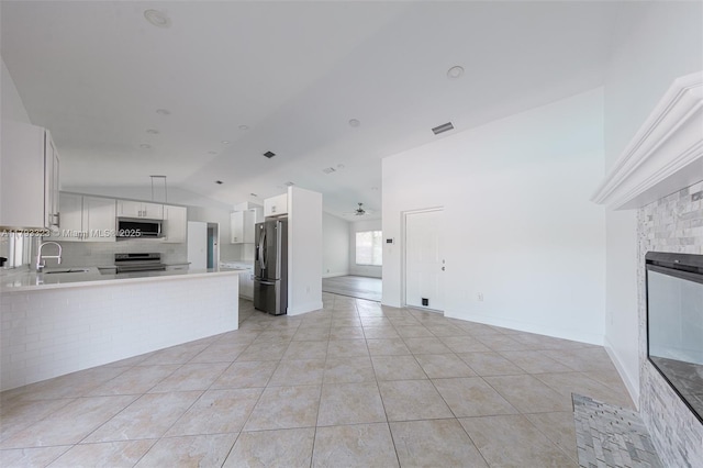 3401 SW 141st Ave, Miramar, FL 33027 - kitchen featuring stainless steel appliances, vaulted ceiling, open floor plan, light tile patterned floors, and tasteful backsplash