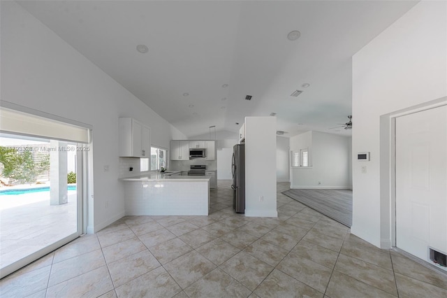 3401 SW 141st Ave, Miramar, FL 33027 - kitchen featuring open floor plan, stainless steel appliances, a peninsula, white cabinets, and vaulted ceiling