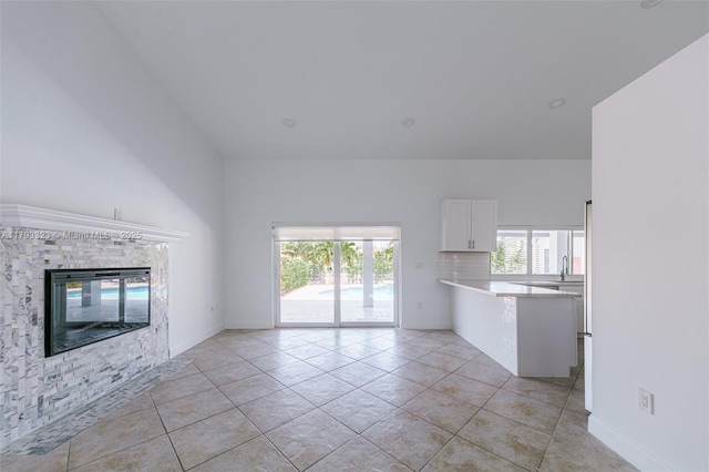 3401 SW 141st Ave, Miramar, FL 33027 - unfurnished living room with a stone fireplace, baseboards, and light tile patterned floors