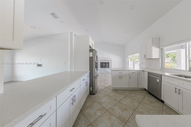 3401 SW 141st Ave, Miramar, FL 33027 - kitchen with appliances with stainless steel finishes, lofted ceiling, a sink, a peninsula, and white cabinetry