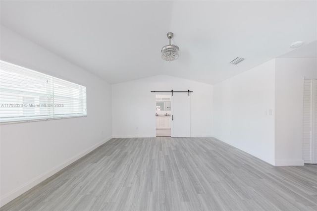3401 SW 141st Ave, Miramar, FL 33027 - spare room with a barn door, vaulted ceiling, light wood-style flooring, and baseboards