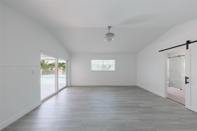 3401 SW 141st Ave, Miramar, FL 33027 - empty room with vaulted ceiling, a barn door, light wood finished floors, and baseboards