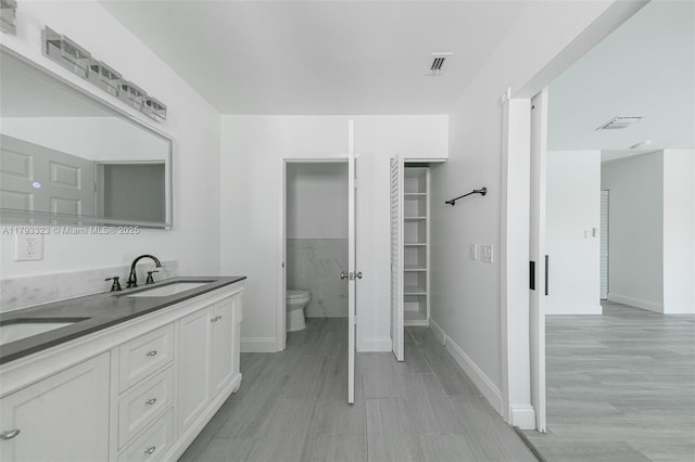 3401 SW 141st Ave, Miramar, FL 33027 - full bathroom with toilet, double vanity, baseboards, and wood finished floors