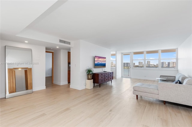 living area featuring recessed lighting, baseboards, visible vents, and light wood-style flooring