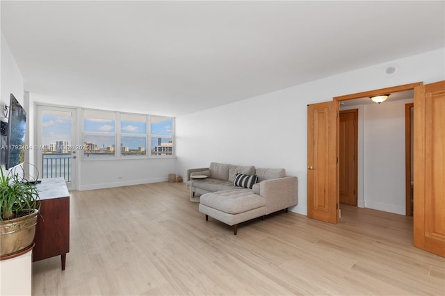 living area featuring baseboards and light wood-type flooring