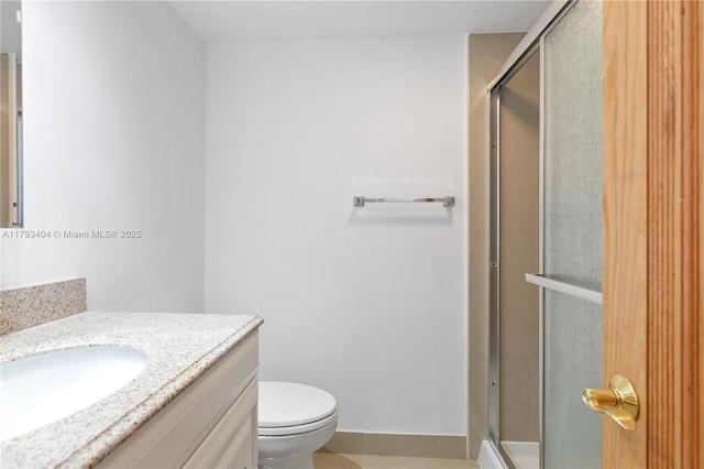 bathroom with vanity, tile patterned floors, toilet, and a shower stall