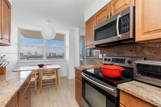 kitchen with a toaster, light stone counters, tasteful backsplash, and stainless steel appliances