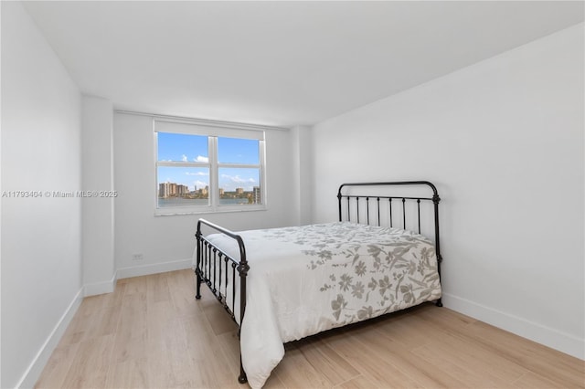 bedroom featuring baseboards and wood finished floors