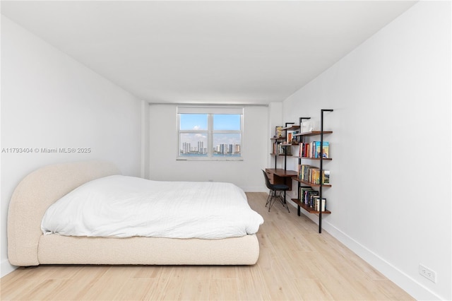 bedroom featuring baseboards and wood finished floors
