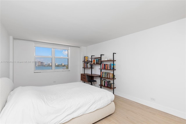 bedroom featuring light wood-style floors and baseboards