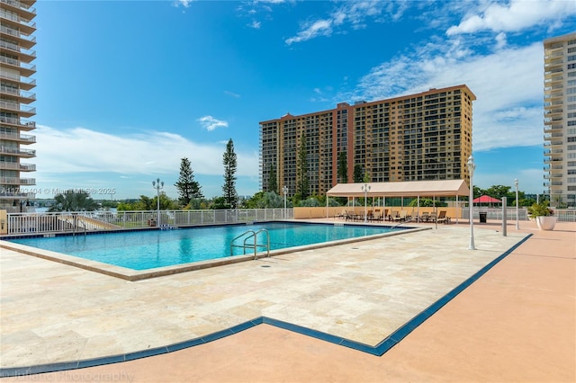 community pool featuring fence and a patio