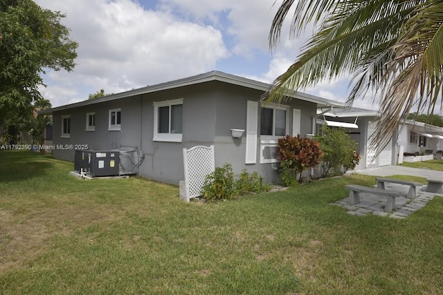 4701 NW 43rd Ave, Tamarac, FL 33319 - back of property with a lawn, central AC, a garage, and stucco siding