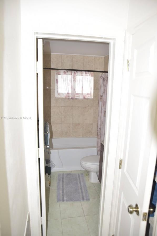 4701 NW 43rd Ave, Tamarac, FL 33319 - full bathroom featuring tile patterned flooring, shower / tub combo with curtain, and toilet