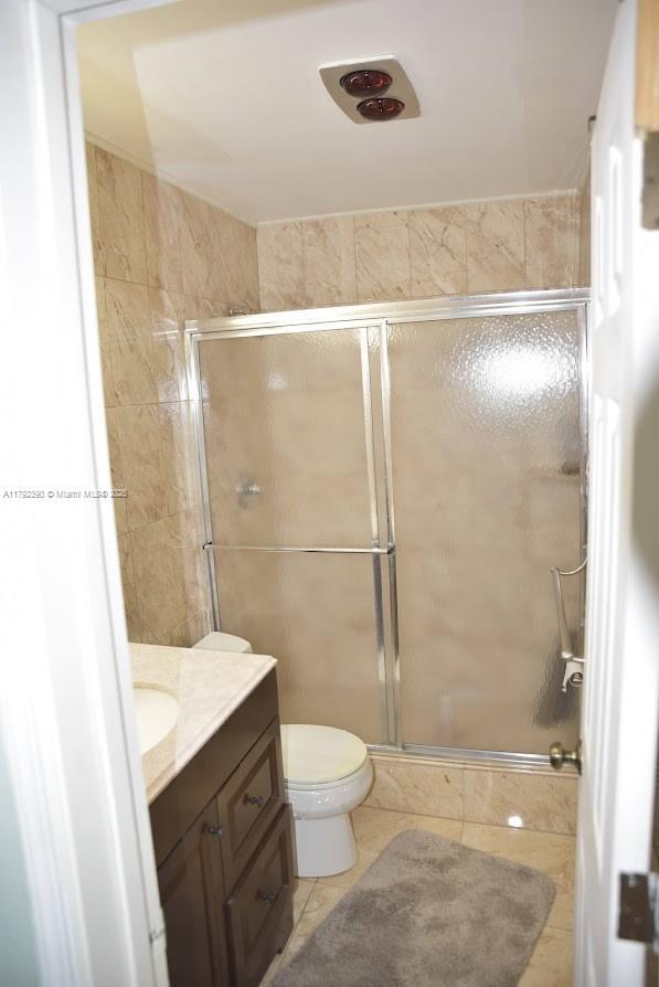 4701 NW 43rd Ave, Tamarac, FL 33319 - bathroom featuring vanity, tile patterned flooring, a shower stall, and toilet