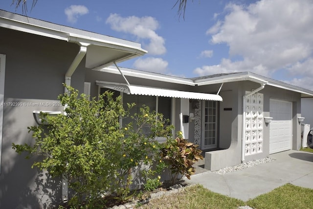 4701 NW 43rd Ave, Tamarac, FL 33319 - property entrance with a garage, stucco siding, and driveway