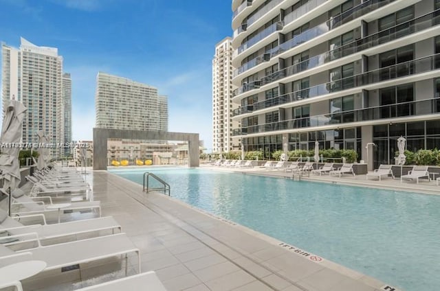 community pool with a view of city and a patio