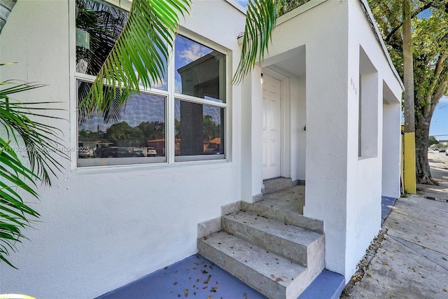 doorway to property featuring stucco siding