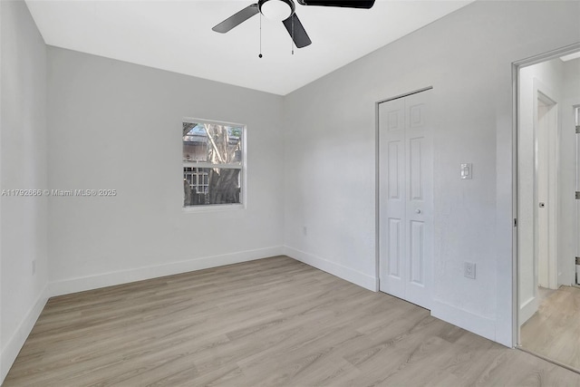 empty room featuring ceiling fan, baseboards, and light wood finished floors