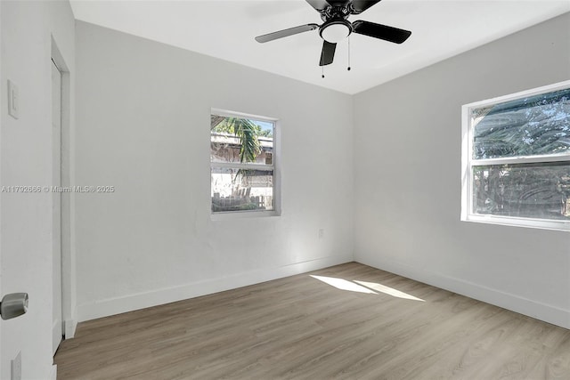 spare room featuring light wood-style floors, baseboards, and ceiling fan