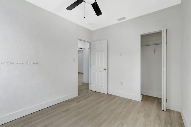 unfurnished bedroom featuring baseboards, a closet, light wood-style flooring, and visible vents