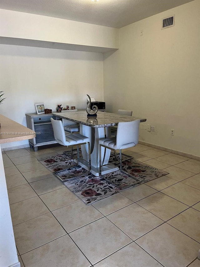 dining space with visible vents, baseboards, and light tile patterned floors