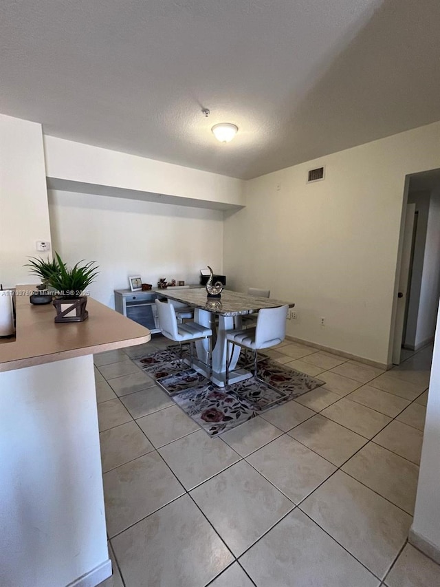 dining area featuring baseboards, visible vents, and light tile patterned floors